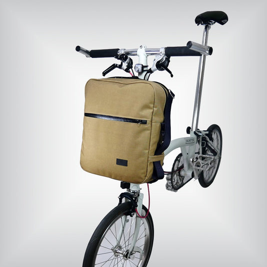 Retro-inspired front bag for Brompton bicycle with adjustable strap and double zipper main compartment.
