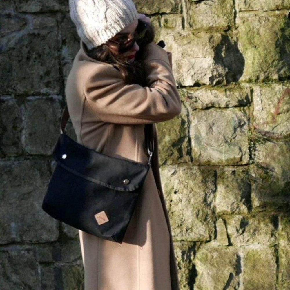 Woman walking on the street with a black crossbody bag