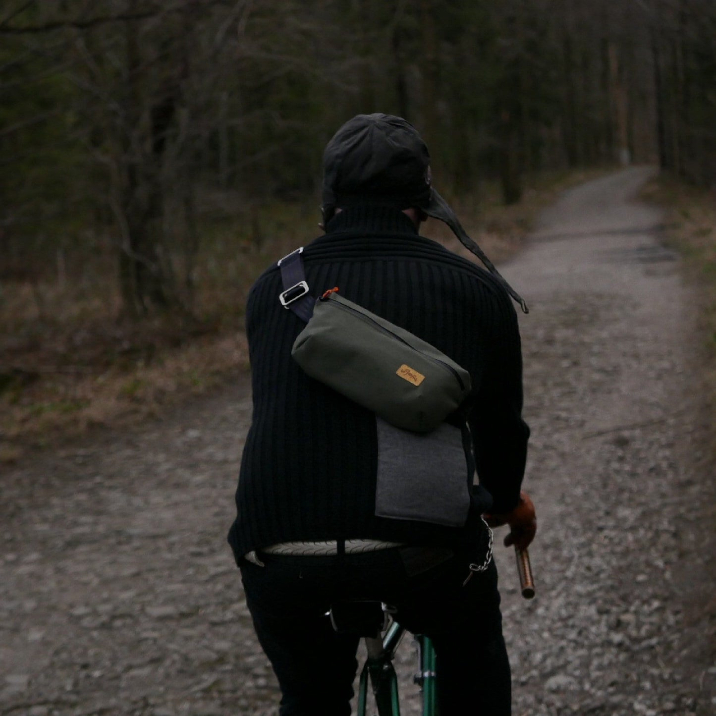 Cyclist on the forrest path wearing khaki cycling sling bag from La Jefa and sons