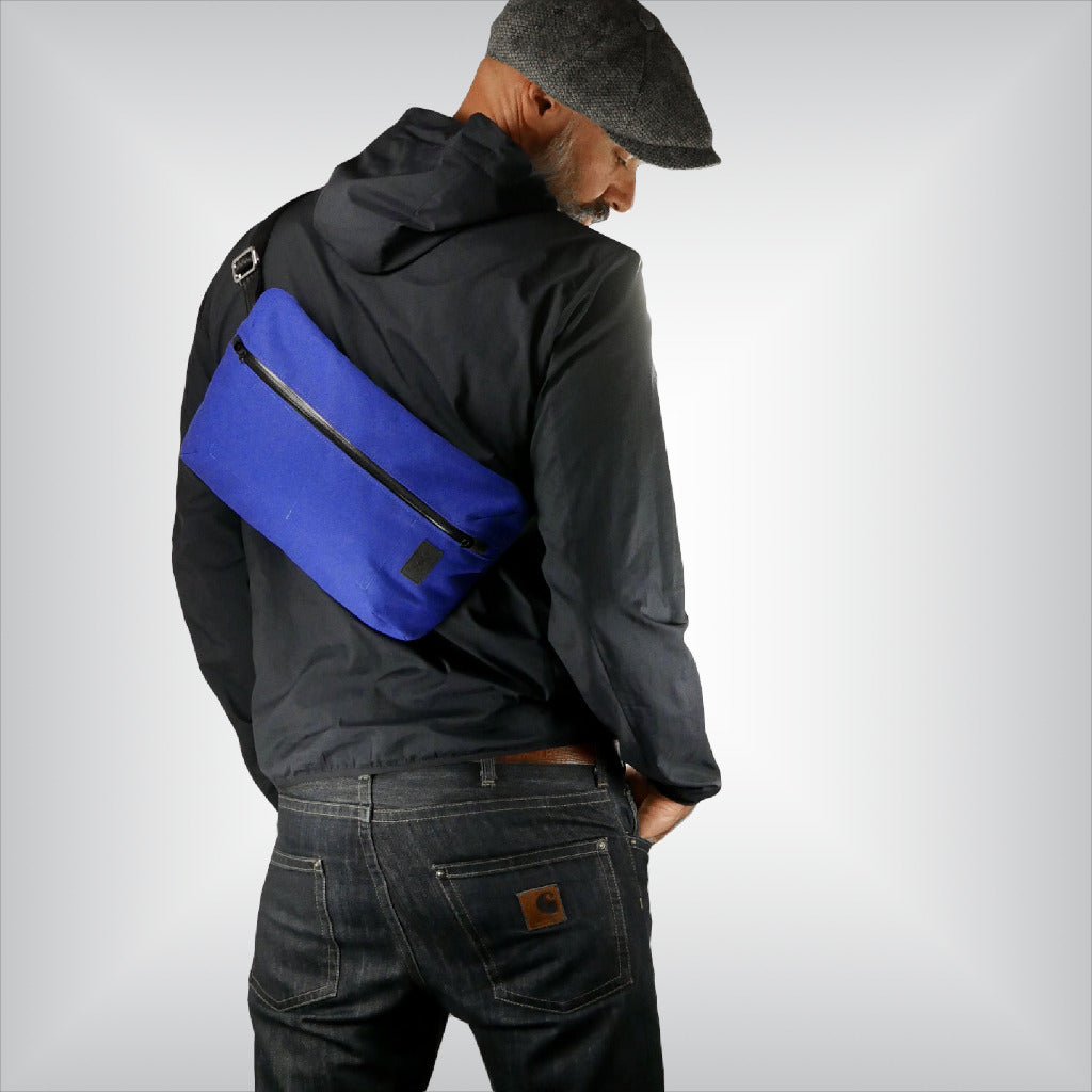 Standing man wearing casual outfit and cobalt blue sling bag