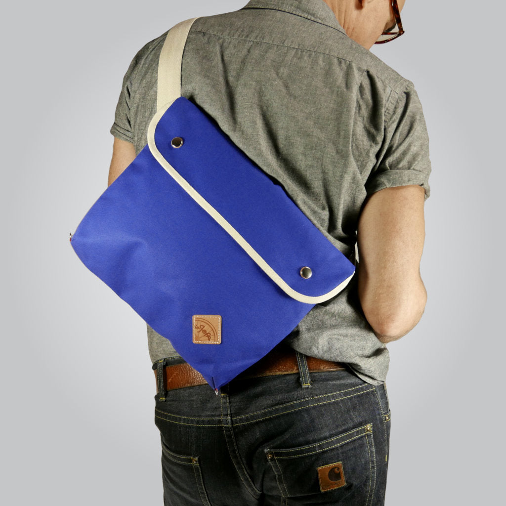 Man in jeans and shirt wearing stylish blue corssbody bag