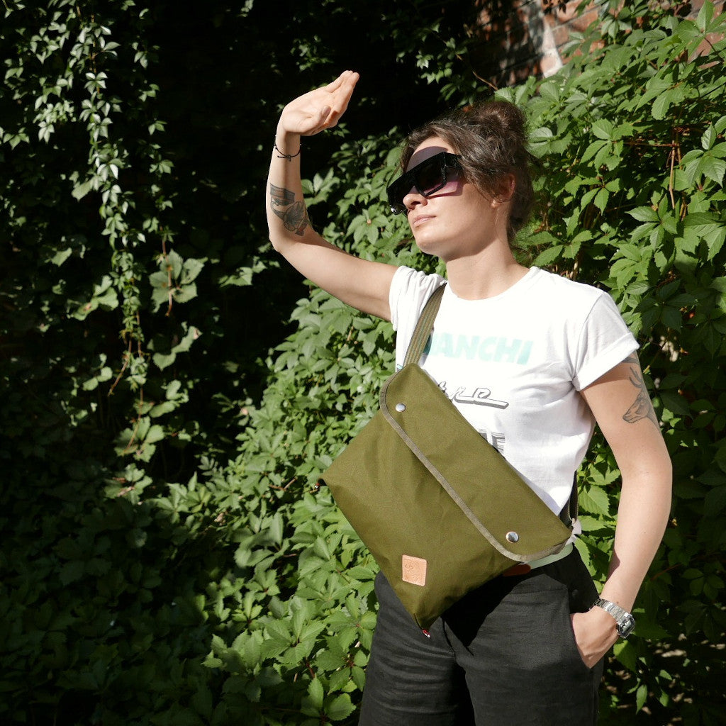 Woman wearing sunglasses and green crossbody bag